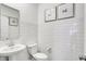 Clean, stylish bathroom featuring a white pedestal sink, toilet, and modern subway tile at 1067 Marston Ln, Avon, IN 46123