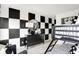 Bedroom featuring a bunk bed, black dresser with decor and a black and white checkered accent wall at 1067 Marston Ln, Avon, IN 46123