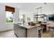 Modern kitchen island with stainless steel appliances and an open view into the dining area at 1067 Marston Ln, Avon, IN 46123