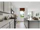 Open kitchen featuring gray cabinets, stainless appliances and a breakfast bar island with sink at 1067 Marston Ln, Avon, IN 46123