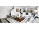 Open-concept living room with stylish furnishings, contemporary decor, and staircase in the background at 1067 Marston Ln, Avon, IN 46123