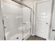 Modern shower with glass door, white tile, and chrome fixtures, providing a clean and sleek look at 1075 Marston Ln, Avon, IN 46123