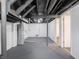 Unfinished basement with water heater, painted floor, and open ceiling at 1132 Sharon Ave, Indianapolis, IN 46222