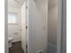 A bright bathroom with white walls, a white toilet, and gray wood-look flooring at 1132 Sharon Ave, Indianapolis, IN 46222
