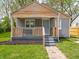 Charming home featuring a covered porch with wood accents and gray siding at 1132 Sharon Ave, Indianapolis, IN 46222