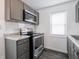 Modern kitchen features stainless steel appliances, gray cabinets, and subway tile backsplash at 1132 Sharon Ave, Indianapolis, IN 46222