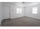 Bright living room with carpet, natural light from windows, and white door at 1132 Sharon Ave, Indianapolis, IN 46222