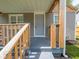 Covered front porch with a natural wood railing and gray painted floor at 1132 Sharon Ave, Indianapolis, IN 46222