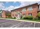 Exterior view of a charming two-story red brick building with beautiful landscaping and a parking lot at 1142 Canterbury S Sq # B, Indianapolis, IN 46260