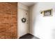A front door on a brick wall with a gold framed picture and wall sconce at 1142 Canterbury S Sq # B, Indianapolis, IN 46260