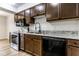 This kitchen has wood cabinets, stainless steel appliances, light counters, and a black dishwasher at 1142 Canterbury S Sq # B, Indianapolis, IN 46260