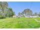 A sprawling grassy backyard features a shed, various structures, and a utility pole at 115 S Center St, Maxwell, IN 46154