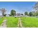 A home with a sunroom sits on a grassy lot with a path leading to other buildings at 115 S Center St, Maxwell, IN 46154