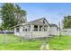 A quaint home with a fenced yard, sunroom and grassy yard sits under a blue sky at 115 S Center St, Maxwell, IN 46154