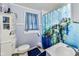 Small bathroom with a white toilet, sink and a shower featuring a turtle themed curtain at 115 S Center St, Maxwell, IN 46154