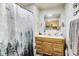 A bathroom with wooden vanity, framed mirror, and a shower featuring a decorative curtain at 115 S Center St, Maxwell, IN 46154