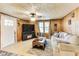 Cozy living room with wood paneled walls, a ceiling fan, comfortable sofa, and a TV with a fireplace at 115 S Center St, Maxwell, IN 46154