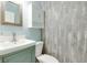 Charming half bath featuring a modern vanity, mirror, storage cabinet and stylish wall coverings at 11614 Buttonwood Dr, Carmel, IN 46033