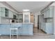 Modern kitchen featuring blue cabinets, granite countertops, stainless steel appliances, and updated lighting at 11614 Buttonwood Dr, Carmel, IN 46033