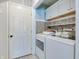 Functional laundry area featuring updated washer and dryer, storage cabinets and light tile floors at 11614 Buttonwood Dr, Carmel, IN 46033