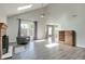 Bright living room with fireplace, vaulted ceiling with skylight, and light gray walls and flooring at 11614 Buttonwood Dr, Carmel, IN 46033