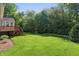 Well-kept backyard with a green lawn, landscaping, and a wooden deck with stairs, ideal for outdoor gatherings at 12065 Gray Eagle Dr, Fishers, IN 46037