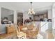 Bright dining room featuring a chandelier, wood floors, and natural light streaming through open kitchen views at 12065 Gray Eagle Dr, Fishers, IN 46037