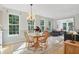 Bright dining room with hardwood floors, many windows, natural light, and a view into the sunroom at 12065 Gray Eagle Dr, Fishers, IN 46037