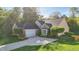 Beautifully landscaped brick home with a well-kept lawn, mature trees, and a long driveway leading to an attached garage at 12065 Gray Eagle Dr, Fishers, IN 46037