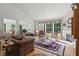 Cozy living room with a fireplace, large windows, hardwood floors, and comfortable seating at 12065 Gray Eagle Dr, Fishers, IN 46037