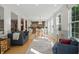 Open-concept living room showcasing hardwood floors, bright windows, and seamless flow into the dining and kitchen areas at 12065 Gray Eagle Dr, Fishers, IN 46037