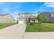 Two-story home with gray siding, stone accents, a two-car garage, and a well-manicured lawn at 1289 Sunset Blvd, Avon, IN 46123