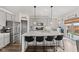 Modern kitchen with gray cabinets, stainless steel appliances, a large island with bar seating, and sliding glass doors at 1289 Sunset Blvd, Avon, IN 46123
