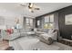 Bright living room featuring a large gray sectional, ceiling fan, and natural light pouring in from multiple windows at 1289 Sunset Blvd, Avon, IN 46123