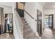 Carpeted staircase with white spindles, wooden handrail, a decorative wall hanging, and dark gray accent wall at 1289 Sunset Blvd, Avon, IN 46123