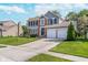 Charming two-story home featuring a two-car garage, manicured lawn, and a combination of brick and gray siding at 13131 Conner Knoll Pkwy, Fishers, IN 46038
