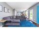 Open living area with gray sectional sofa, blue rug, and a view into the adjacent kitchen and dining area at 13131 Conner Knoll Pkwy, Fishers, IN 46038