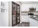 Kitchen pantry with dark wood framed glass doors and organized shelves, showcasing ample storage space at 13131 Conner Knoll Pkwy, Fishers, IN 46038