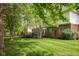 Lush backyard featuring green grass, mature trees, and a patio off the home at 13248 Blacktern Way, Carmel, IN 46033