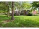 Well-kept backyard features a large lawn, mature trees, and a cozy patio area at 13248 Blacktern Way, Carmel, IN 46033