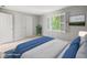 Bright bedroom featuring neutral walls, a large window with shutters, and a comfortable bed with blue accents at 13248 Blacktern Way, Carmel, IN 46033