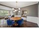 Dining room with hardwood floors, modern lighting, and blue velvet chairs at 13248 Blacktern Way, Carmel, IN 46033