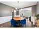 Dining room with hardwood floors, modern lighting, and blue velvet chairs at 13248 Blacktern Way, Carmel, IN 46033