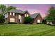 Elegant brick home with arched window and landscaped lawn, bathed in soft twilight at 13248 Blacktern Way, Carmel, IN 46033