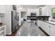 Bright kitchen featuring white cabinets, stainless steel appliances, a granite island, and hardwood floors at 13248 Blacktern Way, Carmel, IN 46033