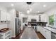 Bright kitchen featuring white cabinets, stainless steel appliances, granite countertops, and hardwood floors at 13248 Blacktern Way, Carmel, IN 46033