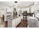 Bright kitchen featuring white cabinets, stainless steel appliances, a granite island, and hardwood floors at 13248 Blacktern Way, Carmel, IN 46033