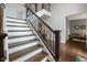 Elegant staircase with dark wood rails, white risers, and open design, enhancing the home's architectural details at 13248 Blacktern Way, Carmel, IN 46033