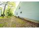 View of backyard features lush trees and lawn beside home with light vinyl siding and mulched flower bed at 1334 Legacy Ct, Indianapolis, IN 46234
