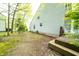 The backyard features a grassy area, mulched flower bed, and a wooden deck with white chairs at 1334 Legacy Ct, Indianapolis, IN 46234